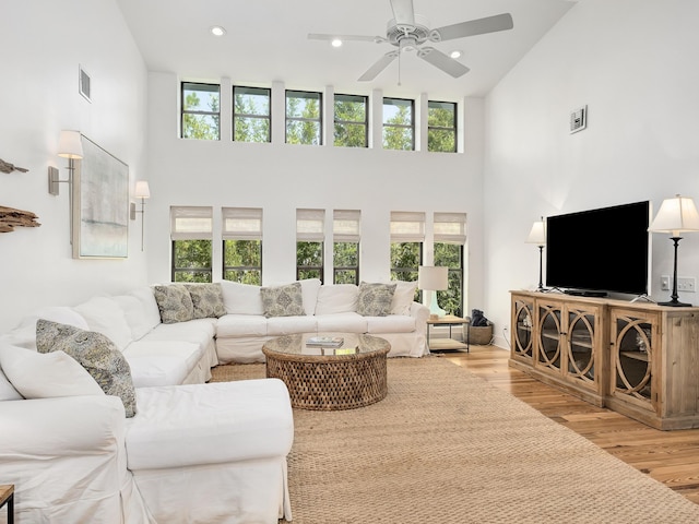 living room featuring light wood-type flooring, high vaulted ceiling, and a wealth of natural light