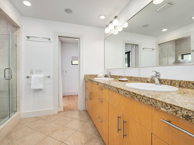 bathroom featuring vanity, tile patterned flooring, and walk in shower