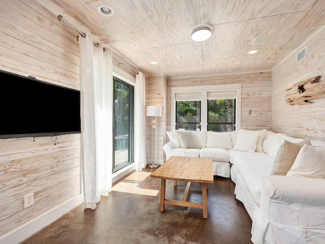 living room with wood ceiling, wood walls, and concrete floors