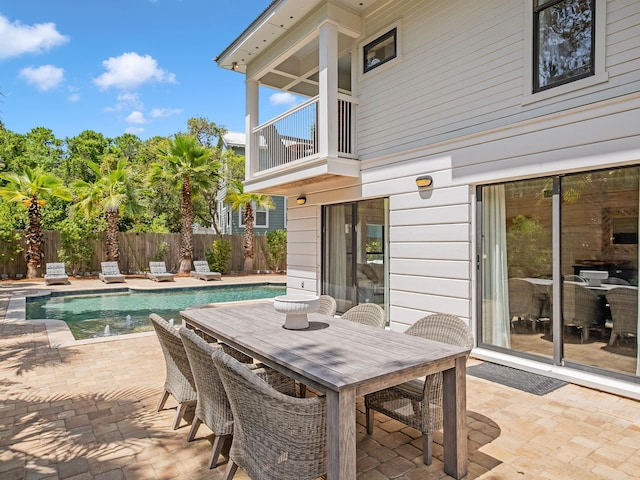 view of patio featuring a fenced in pool and a balcony