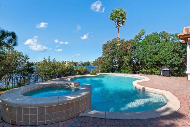 view of swimming pool with a patio, an in ground hot tub, and grilling area