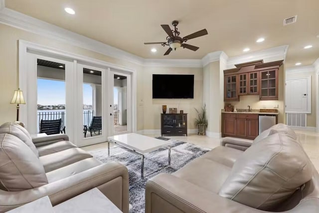 living room with ornamental molding, sink, and ceiling fan