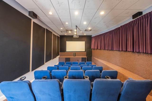 carpeted home theater room featuring a drop ceiling