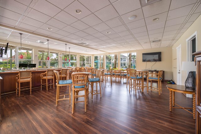 dining room featuring a drop ceiling and dark hardwood / wood-style floors