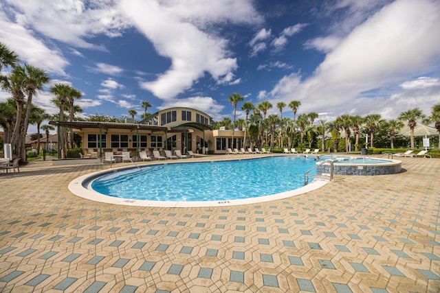 view of swimming pool featuring a hot tub and a patio area