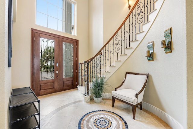 foyer with french doors and a towering ceiling