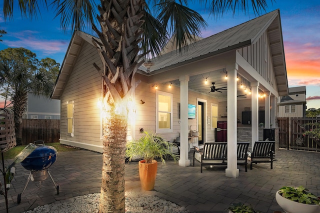 back house at dusk with a patio and ceiling fan