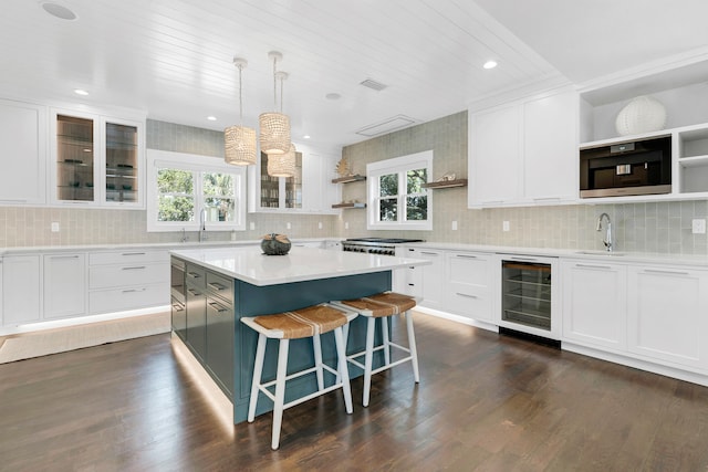 kitchen with wine cooler, plenty of natural light, and white cabinets