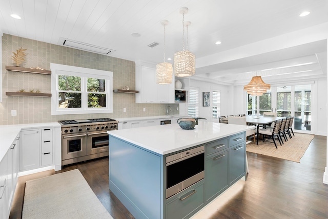 kitchen featuring pendant lighting, stainless steel appliances, a center island, and a healthy amount of sunlight