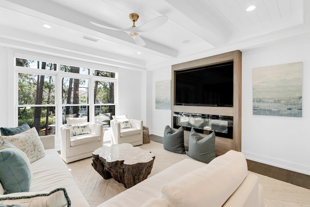 living room with ceiling fan, beam ceiling, and hardwood / wood-style floors