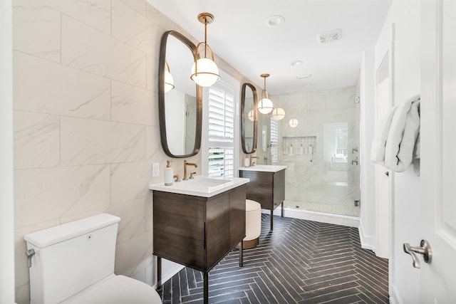 bathroom with an enclosed shower, tile walls, vanity, and toilet