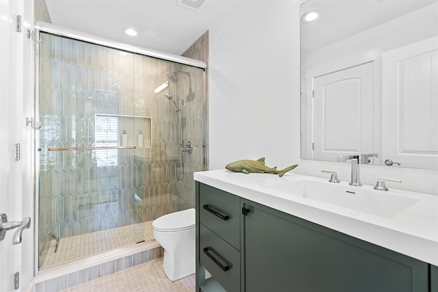 bathroom featuring a shower with door, vanity, and toilet