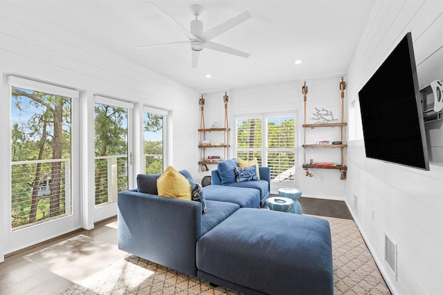 living room with hardwood / wood-style flooring, plenty of natural light, and wood walls