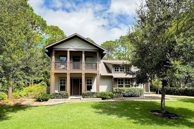 view of front facade with a front yard and a balcony