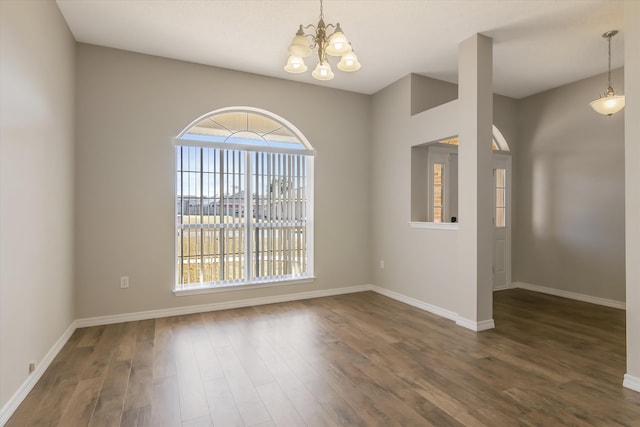 empty room with an inviting chandelier and dark wood-type flooring