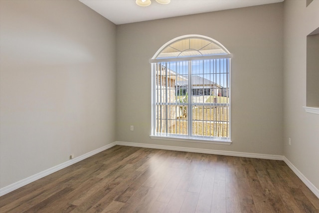 spare room with a healthy amount of sunlight and dark hardwood / wood-style flooring