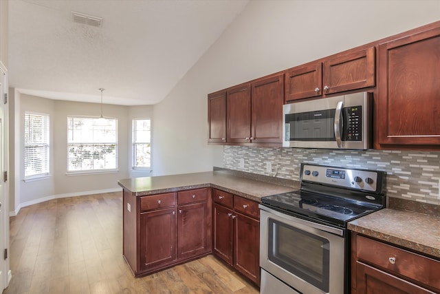 kitchen featuring tasteful backsplash, light wood-type flooring, kitchen peninsula, stainless steel appliances, and vaulted ceiling