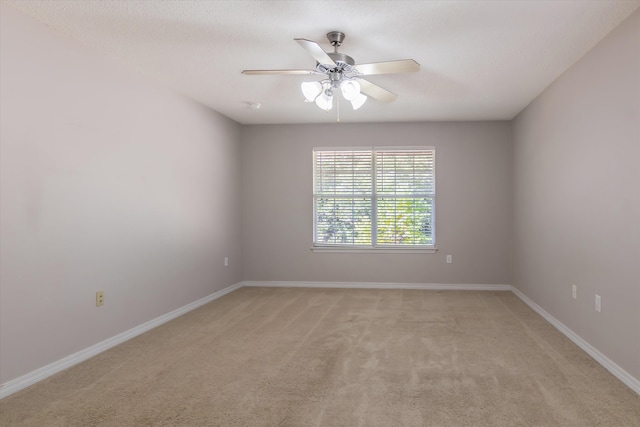 spare room with light colored carpet and ceiling fan