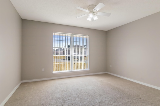 carpeted empty room featuring ceiling fan and plenty of natural light