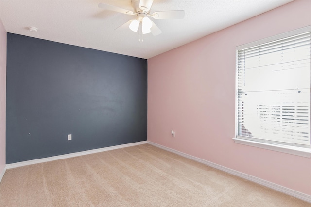 unfurnished room with ceiling fan and light carpet