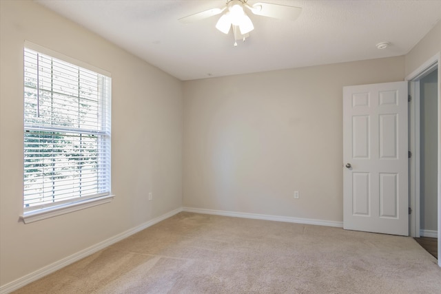 carpeted empty room featuring ceiling fan