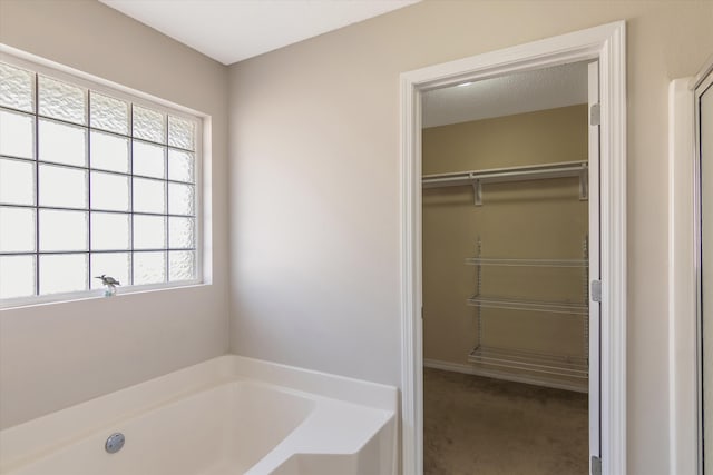 bathroom featuring a bathing tub and a textured ceiling