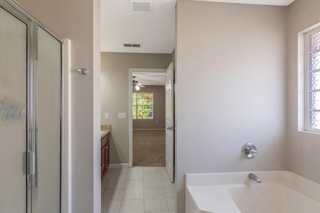 bathroom featuring vanity, independent shower and bath, and a healthy amount of sunlight