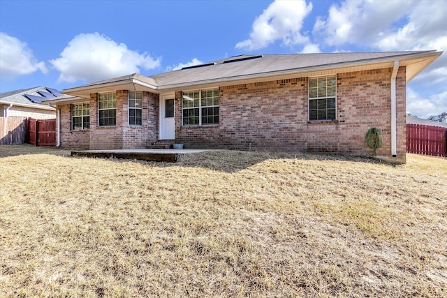 back of property with a yard and a patio area