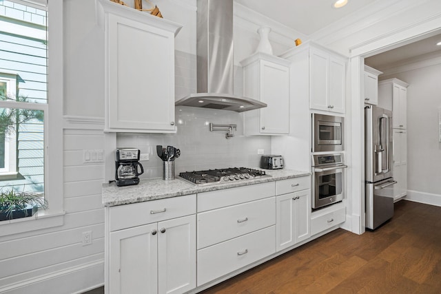 kitchen featuring wall chimney range hood, appliances with stainless steel finishes, and white cabinets