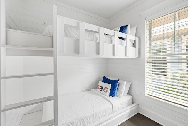 bedroom with wood walls and wood-type flooring