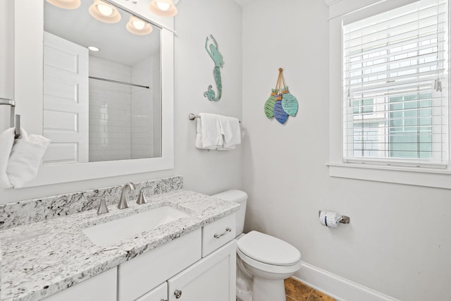 bathroom featuring vanity, toilet, tiled shower, and tile patterned flooring