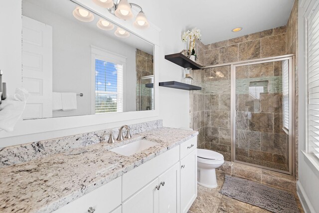 bathroom featuring vanity, toilet, and walk in shower