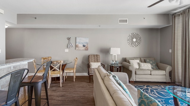 living room featuring ceiling fan and dark hardwood / wood-style flooring