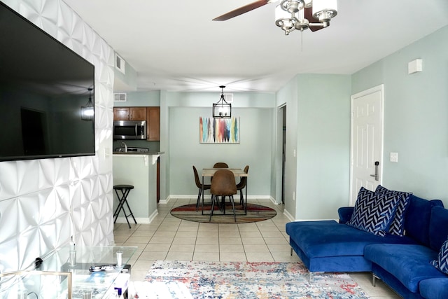 tiled living room with an inviting chandelier