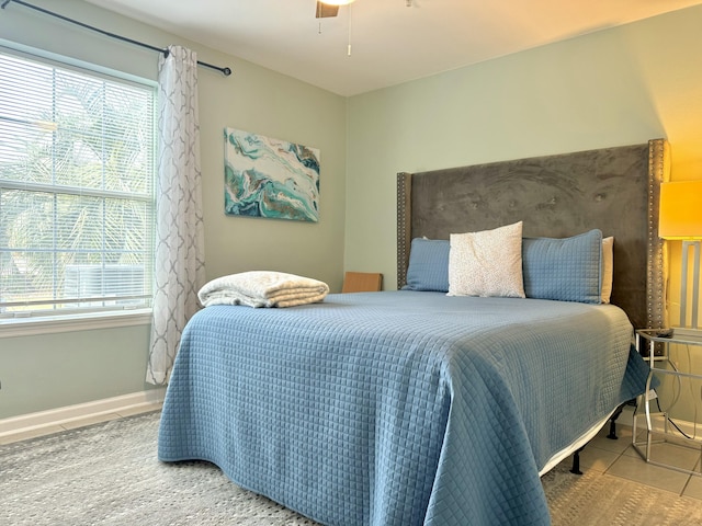 bedroom with ceiling fan and tile patterned flooring