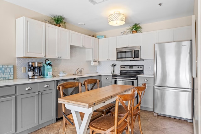 kitchen with white cabinetry, stainless steel appliances, and gray cabinetry