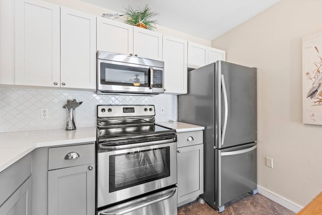 kitchen featuring appliances with stainless steel finishes, gray cabinetry, white cabinetry, and tasteful backsplash