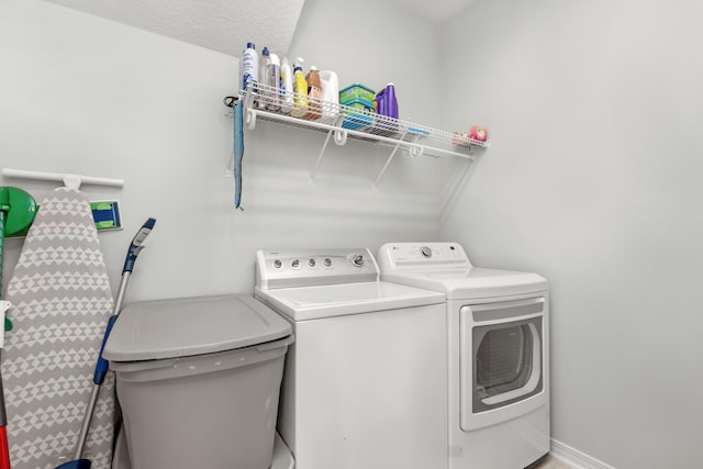 laundry area with washer and dryer and a textured ceiling