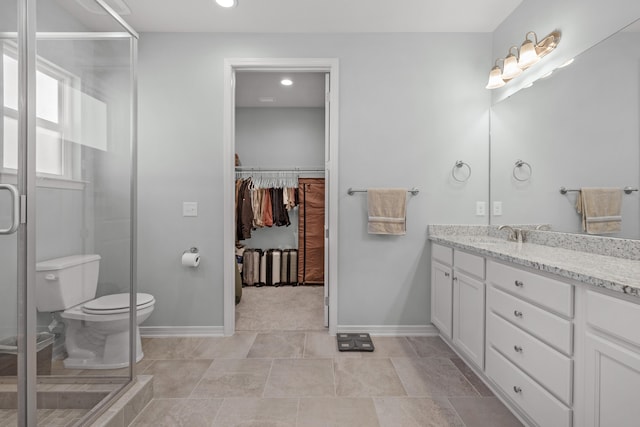 bathroom with toilet, walk in shower, and vanity