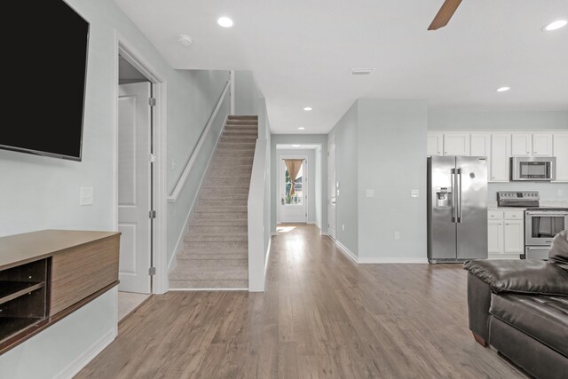 living room with light hardwood / wood-style floors and ceiling fan