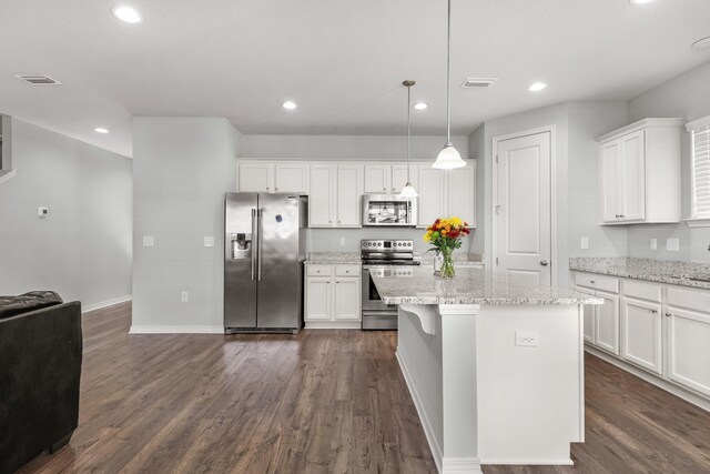 kitchen featuring appliances with stainless steel finishes, pendant lighting, white cabinets, and dark hardwood / wood-style flooring