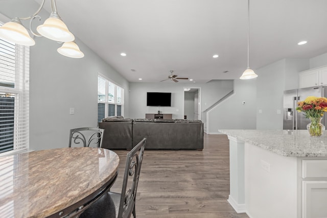 dining area with ceiling fan and wood-type flooring