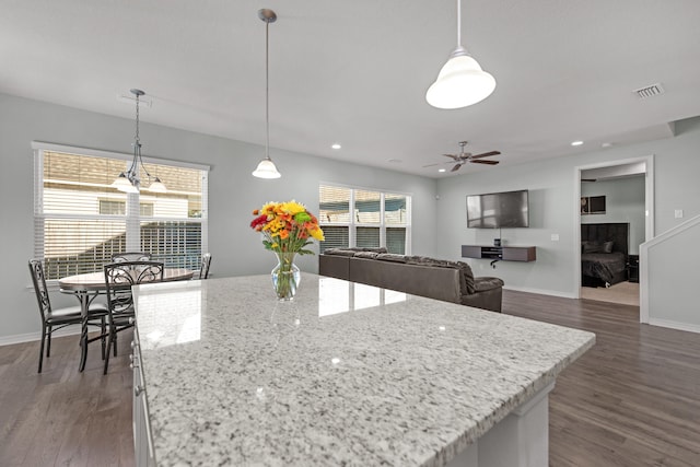 kitchen with dark wood-type flooring, a healthy amount of sunlight, and hanging light fixtures