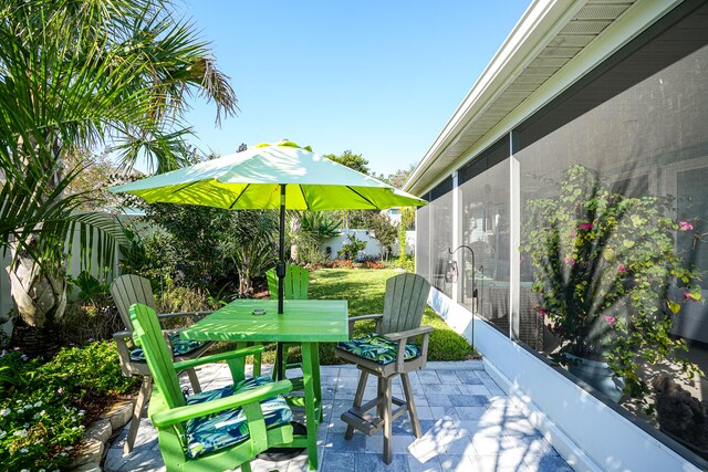 view of patio featuring a sunroom