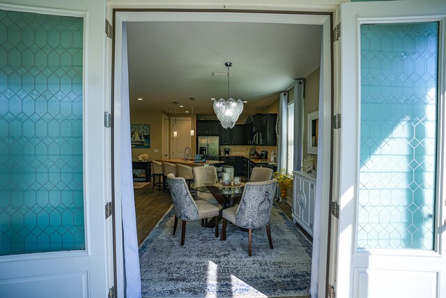 dining space featuring an inviting chandelier, hardwood / wood-style flooring, and sink