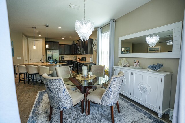 dining room with an inviting chandelier, dark hardwood / wood-style floors, and sink