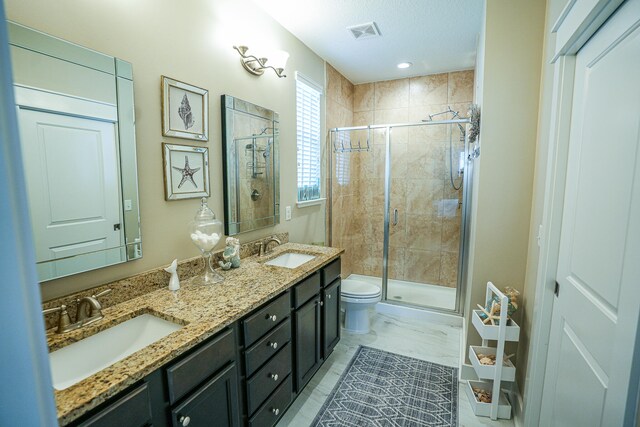 bathroom with a shower with door, toilet, and vanity