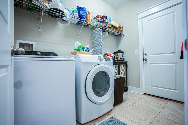 washroom featuring light tile patterned floors and washing machine and clothes dryer