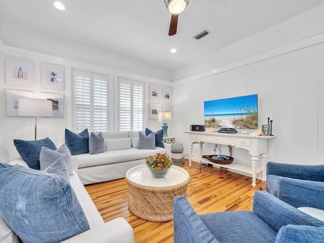 living room featuring ceiling fan and hardwood / wood-style flooring