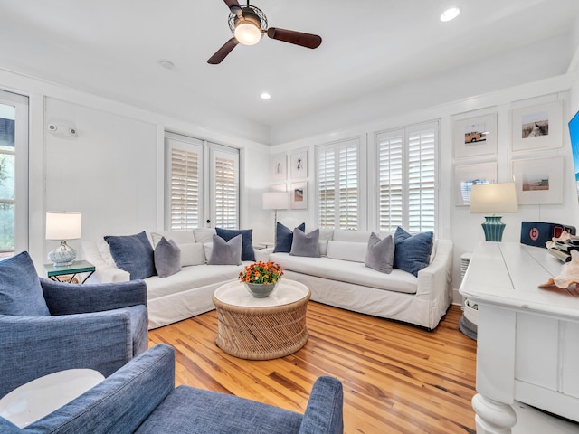 living room with light wood-type flooring and ceiling fan